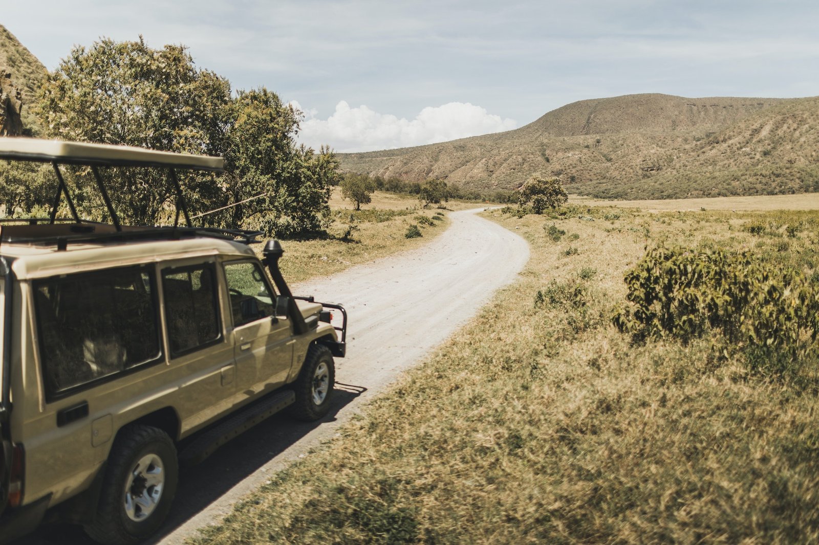 Safari in Hell's Gate national park in Kenya. Off road jeep car, savannah and mountain view