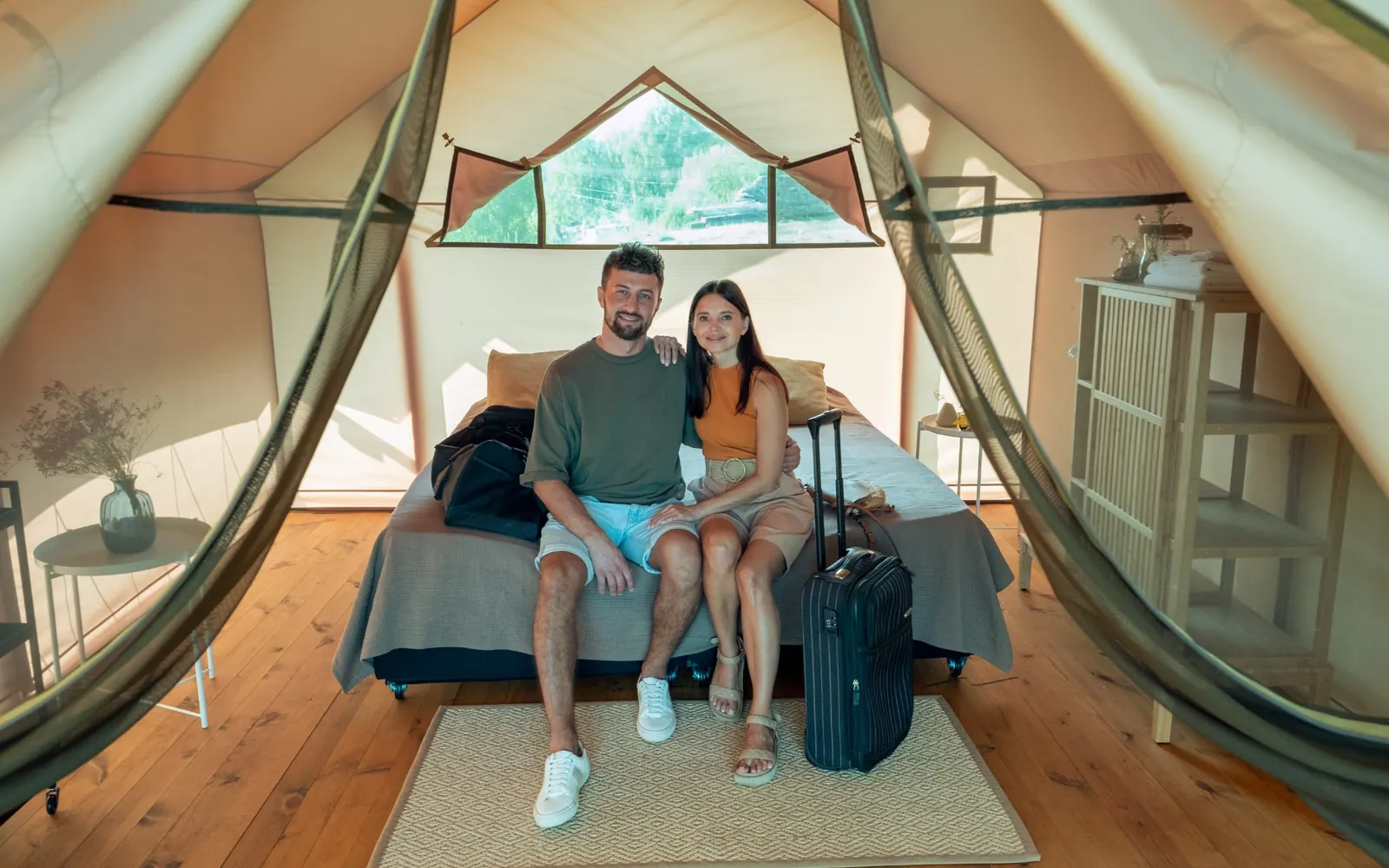 A couple seated at the entrance of a tented room.