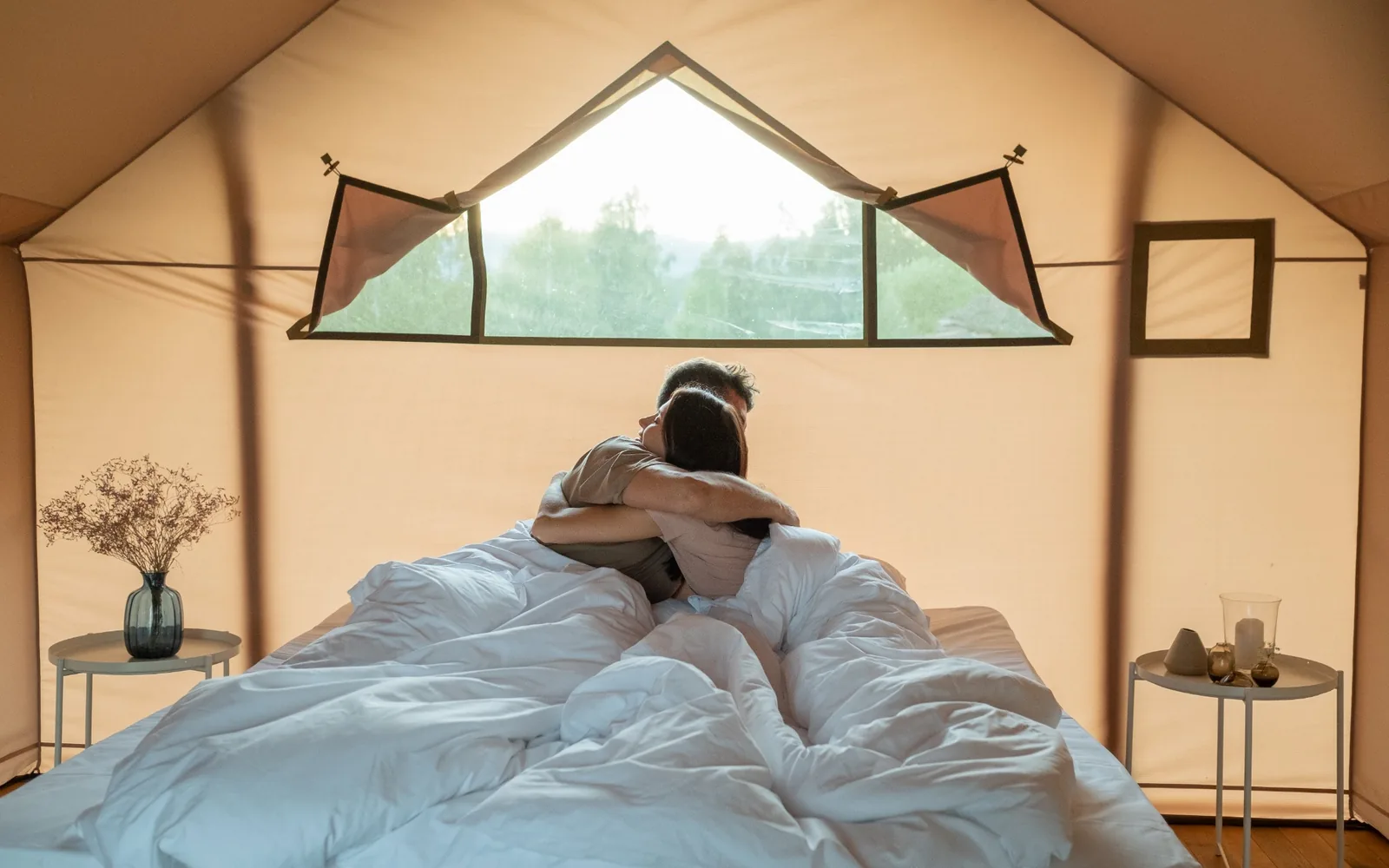 A couple relaxing inside a canvas-walled room.